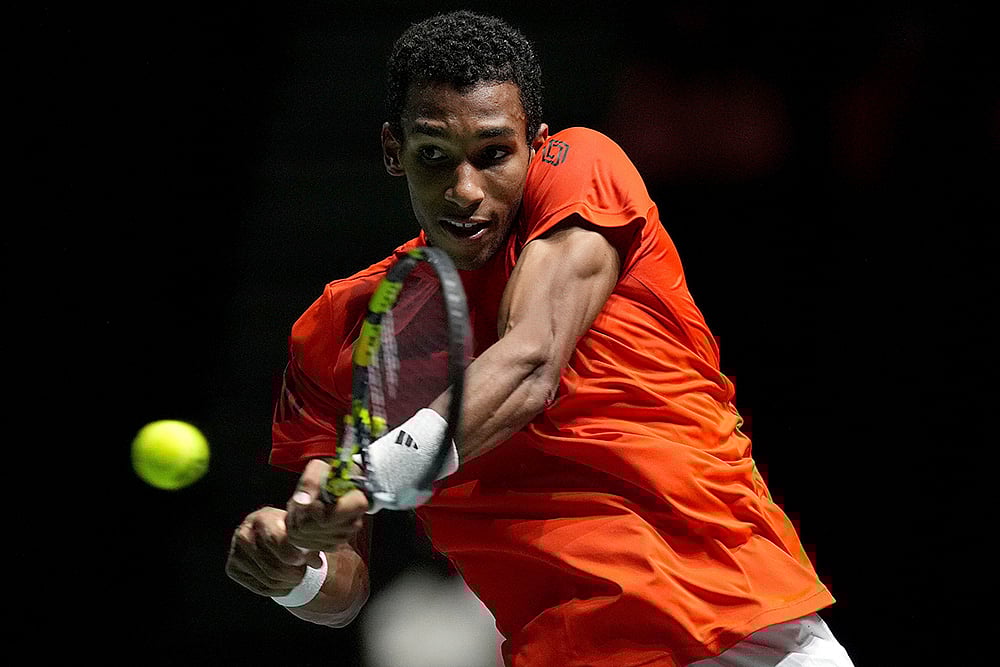 | Photo: Martin Rickett/PA via AP : Davis Cup Tennis, Argentina vs Canada: Canada's Felix Auger Aliassime returns the ball to Argentina's Sebastian Baez